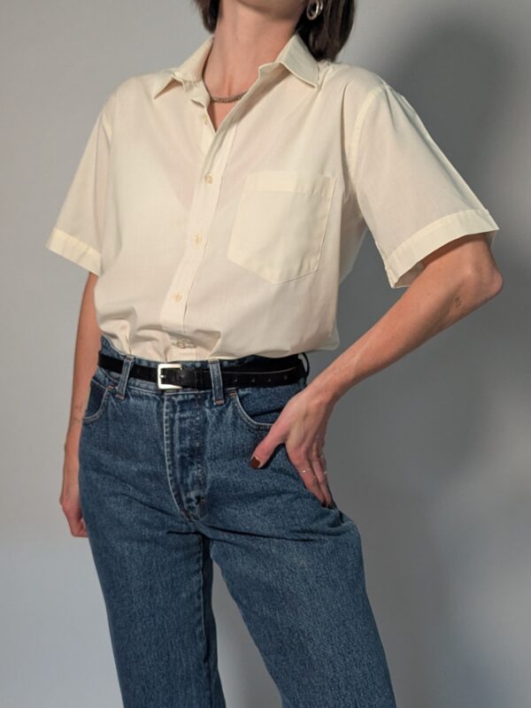Soft shell 01 Vintage crèmekleurige blouse met korte mouwen, borstzak en luchtige pasvorm.