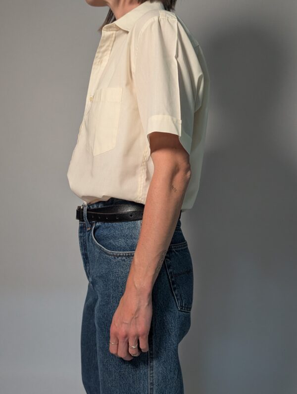 Vintage crèmekleurige blouse met korte mouwen, borstzak en luchtige pasvorm.