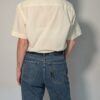 Vintage crèmekleurige blouse met korte mouwen, borstzak en luchtige pasvorm.