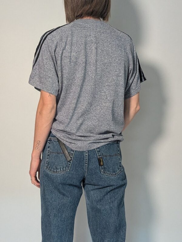 Sporty grey 04 Vintage Adidas T-shirt in gemêleerd grijs met korte mouwen, zwarte schouderstrepen en subtiel logo op de borst.