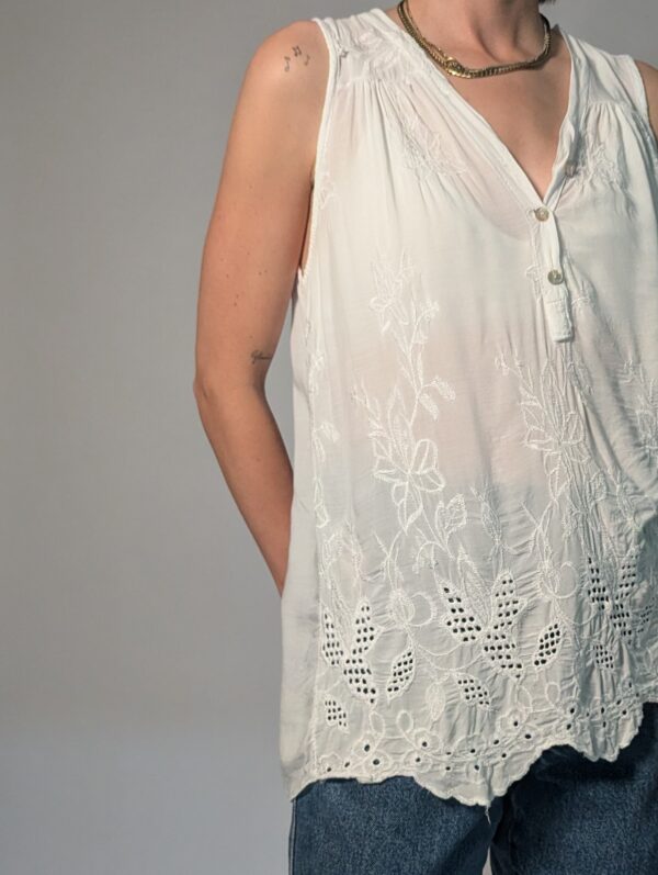 Vintage witte mouwloze top met borduurdetails, V-hals met knoopsluiting en luchtige pasvorm.