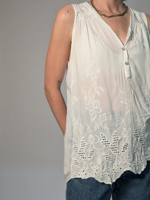 Vintage witte mouwloze top met borduurdetails, V-hals met knoopsluiting en luchtige pasvorm.