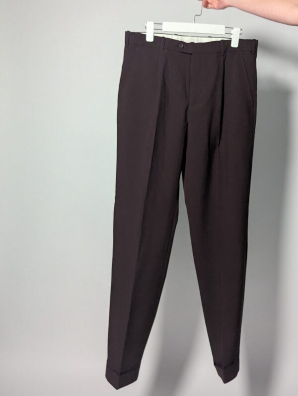 Aubergine line 01 Vintage auberginekleurige pantalon met hoge taille, subtiele plooien en taps toelopende pijpen op hanger gefotografeerd.