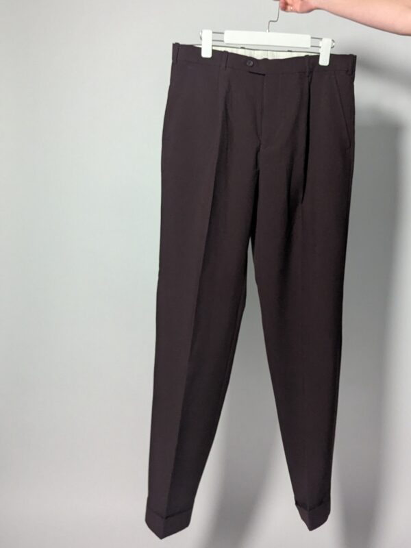 Aubergine line 01 Vintage auberginekleurige pantalon met hoge taille, subtiele plooien en taps toelopende pijpen op hanger gefotografeerd.