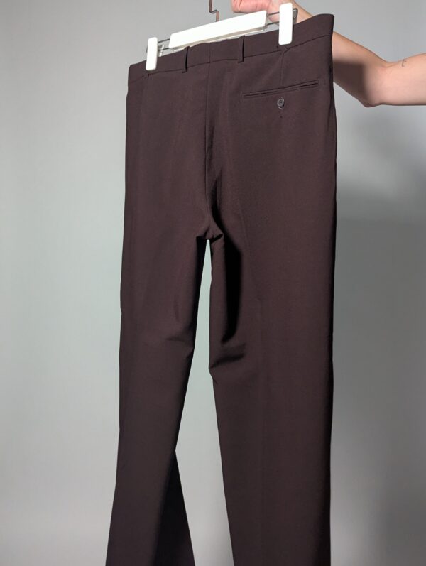 Aubergine line 02 Vintage auberginekleurige pantalon met hoge taille, subtiele plooien en taps toelopende pijpen op hanger gefotografeerd.