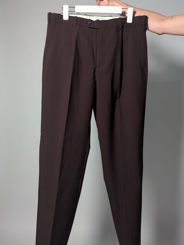 Aubergine line 03 Vintage auberginekleurige pantalon met hoge taille, subtiele plooien en taps toelopende pijpen op hanger gefotografeerd.