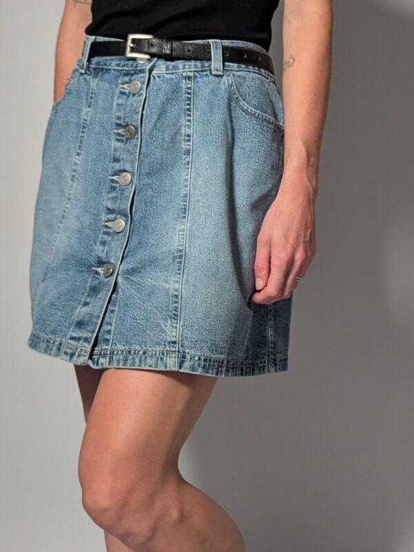 Denim button 01 Vintage lichtblauwe denim rok met hoge taille, rechte pasvorm en knoopsluiting aan de voorkant.