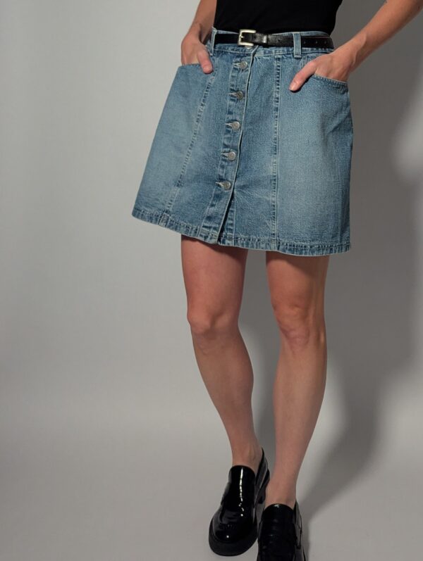 Denim button 03 Vintage lichtblauwe denim rok met hoge taille, rechte pasvorm en knoopsluiting aan de voorkant.