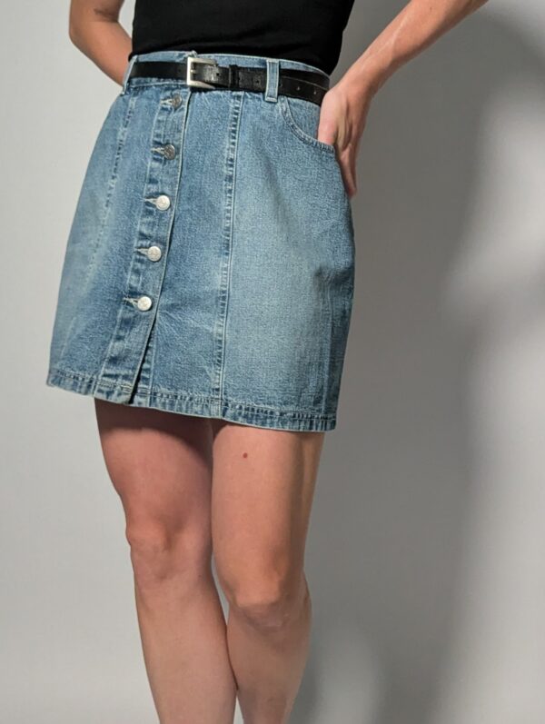 Denim button 04 Vintage lichtblauwe denim rok met hoge taille, rechte pasvorm en knoopsluiting aan de voorkant.