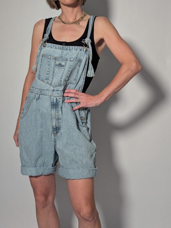 Vintage lichtblauwe denim overall met korte broekspijpen, verstelbare schouderbanden en relaxte pasvorm.