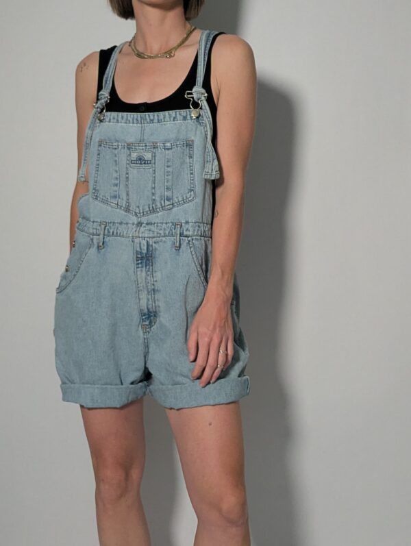 Denim overall 04 Vintage lichtblauwe denim overall met korte broekspijpen, verstelbare schouderbanden en relaxte pasvorm.