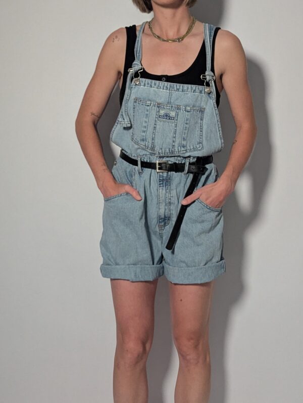 Denim overall 05 Vintage lichtblauwe denim overall met korte broekspijpen, verstelbare schouderbanden en relaxte pasvorm.