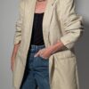 Vintage blazer in zachte ivoor- en beigetint met fijne krijtstreep, klassieke revers en rechte licht oversized pasvorm.