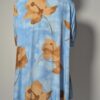Vintage lichtblauwe blousejurk met grote bloemenprint in zand-, oker- en rozetinten, korte mouwen en knoopsluiting.