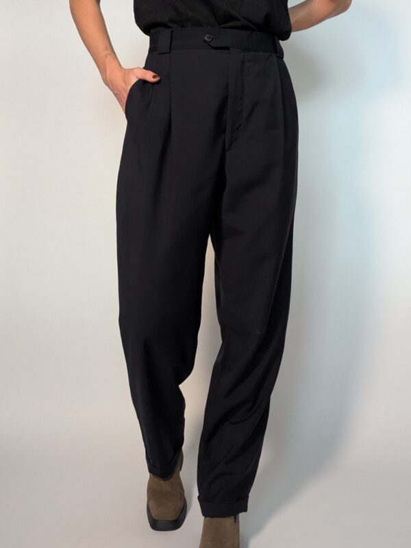 Vintage donkerblauwe pantalon met hoge taille, subtiele plooien en taps toelopende pasvorm.