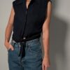 Vintage donkerblauwe mouwloze blouse met plisséstructuur, klassieke kraag, knoopsluiting en strikdetail aan de onderzijde.