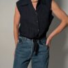 Vintage donkerblauwe mouwloze blouse met plisséstructuur, klassieke kraag, knoopsluiting en strikdetail aan de onderzijde.