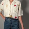 Vintage off-white blouse met korte mouwen, rode rozenprint en opgestikte borstzakken.