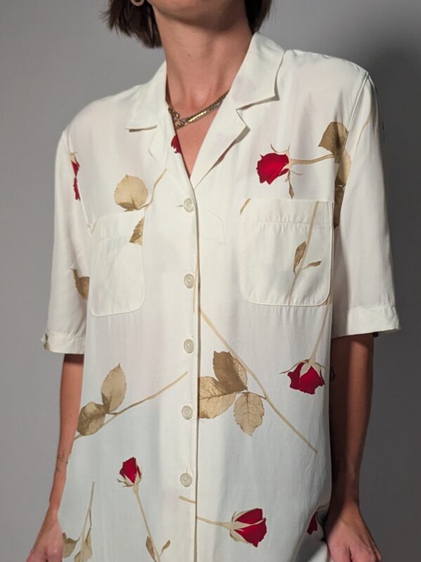 Vintage off-white blouse met korte mouwen, rode rozenprint en opgestikte borstzakken.