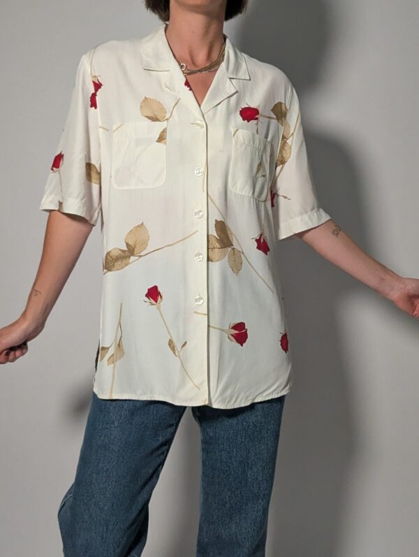 Vintage off-white blouse met korte mouwen, rode rozenprint en opgestikte borstzakken.