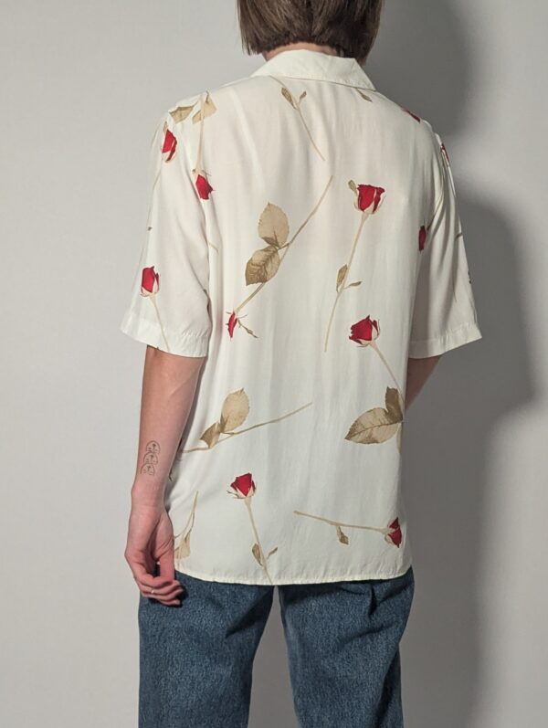 Vintage off-white blouse met korte mouwen, rode rozenprint en opgestikte borstzakken.