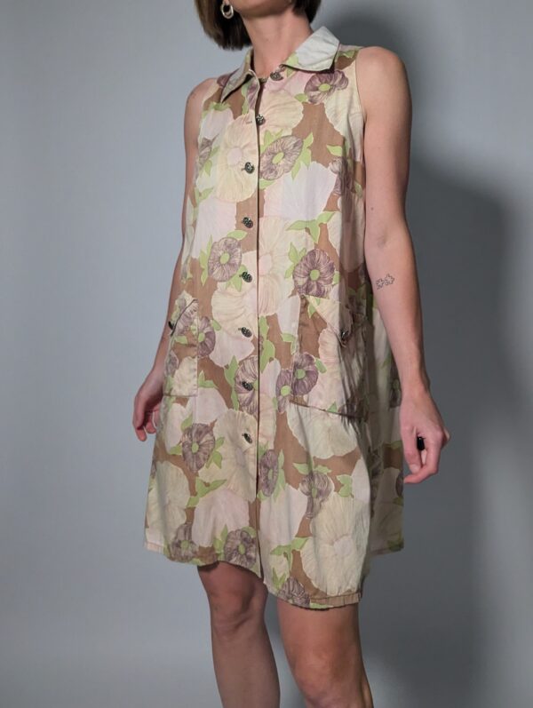Soft floral 01 Vintage mouwloze jurk in beige- en zandtinten met bloemenprint, doorknoopsluiting en rechte pasvorm.
