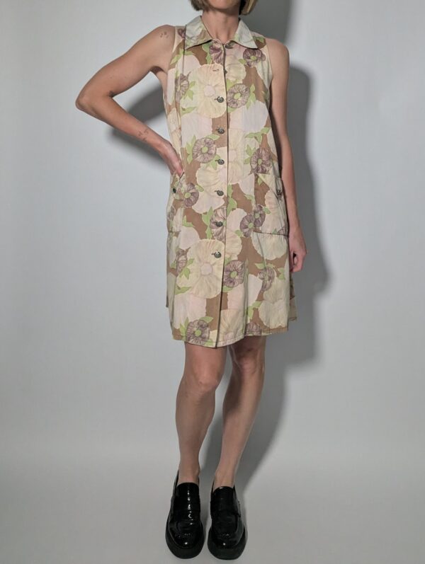 Soft floral 02 Vintage mouwloze jurk in beige- en zandtinten met bloemenprint, doorknoopsluiting en rechte pasvorm.