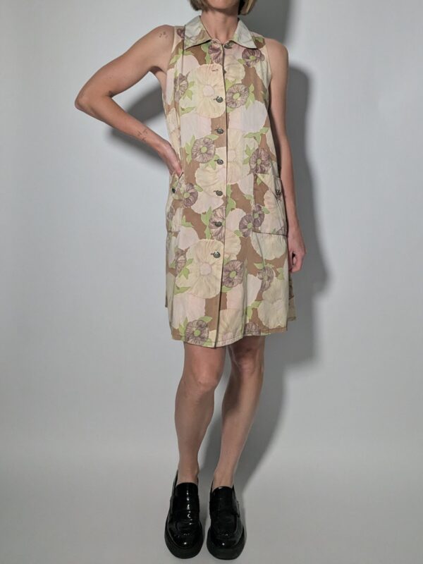 Vintage mouwloze jurk in beige- en zandtinten met bloemenprint, doorknoopsluiting en rechte pasvorm.