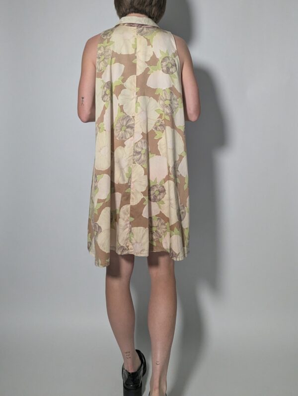 Soft floral 03 Vintage mouwloze jurk in beige- en zandtinten met bloemenprint, doorknoopsluiting en rechte pasvorm.