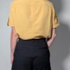 Sunlit pleat 02 Vintage lichtoranje blouse met korte mouwen, plooidetails aan de voorkant en opgerolde mouwen met tab detail.