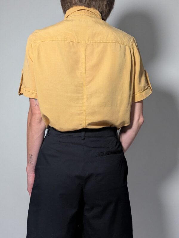 Vintage lichtoranje blouse met korte mouwen, plooidetails aan de voorkant en opgerolde mouwen met tab detail.