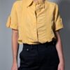 Sunlit pleat 03 Vintage lichtoranje blouse met korte mouwen, plooidetails aan de voorkant en opgerolde mouwen met tab detail.