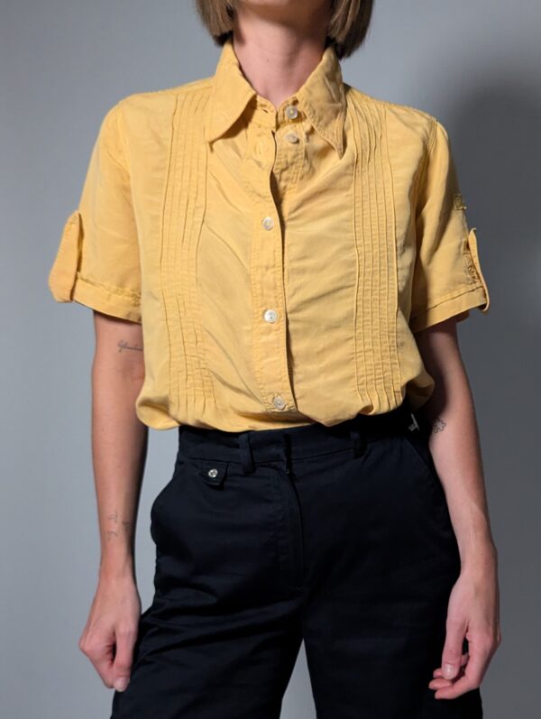 Sunlit pleat 03 Vintage lichtoranje blouse met korte mouwen, plooidetails aan de voorkant en opgerolde mouwen met tab detail.