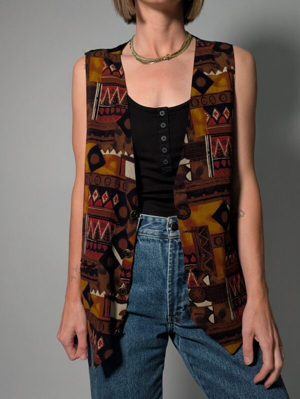 Tribal tone 01 Vintage mouwloos gilet in bruin-, roest- en okergele tinten met grafische print en knoopsluiting aan de voorkant.