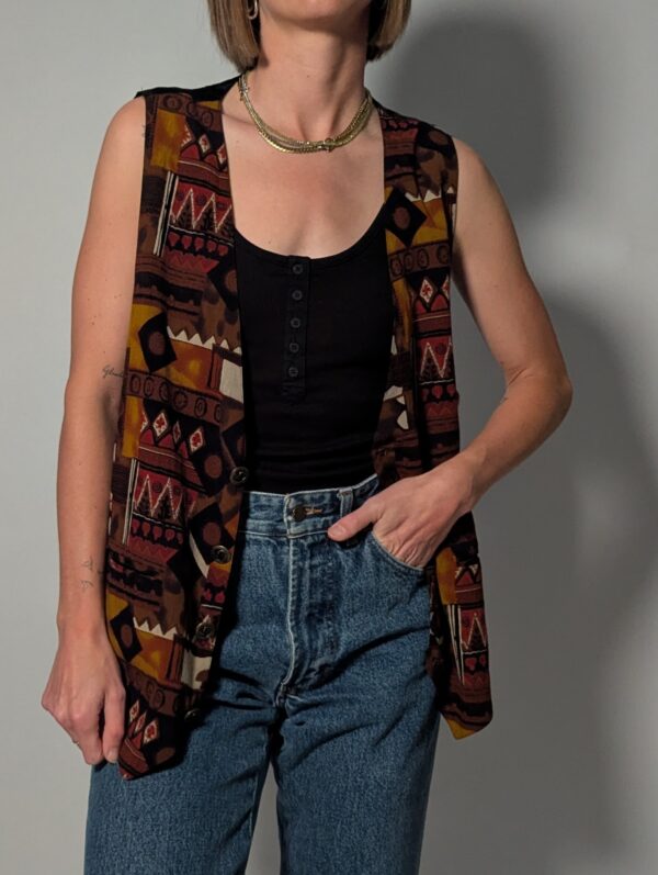 Tribal tone 02 Vintage mouwloos gilet in bruin-, roest- en okergele tinten met grafische print en knoopsluiting aan de voorkant.