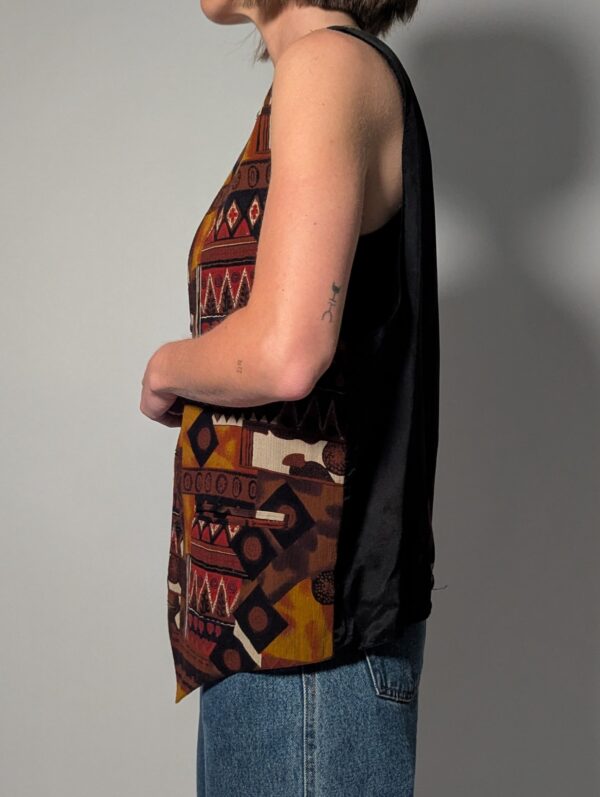 Tribal tone 03 Vintage mouwloos gilet in bruin-, roest- en okergele tinten met grafische print en knoopsluiting aan de voorkant.
