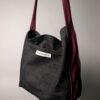 (RE)MADE BY LOT zwarte denim tas met schuine pocket en hengsels gemaakt van een hergebruikte bordeauxrode stropdas.
