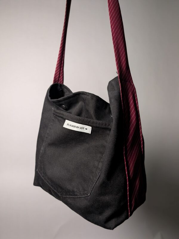 (RE)MADE BY LOT zwarte denim tas met schuine pocket en hengsels gemaakt van een hergebruikte bordeauxrode stropdas.