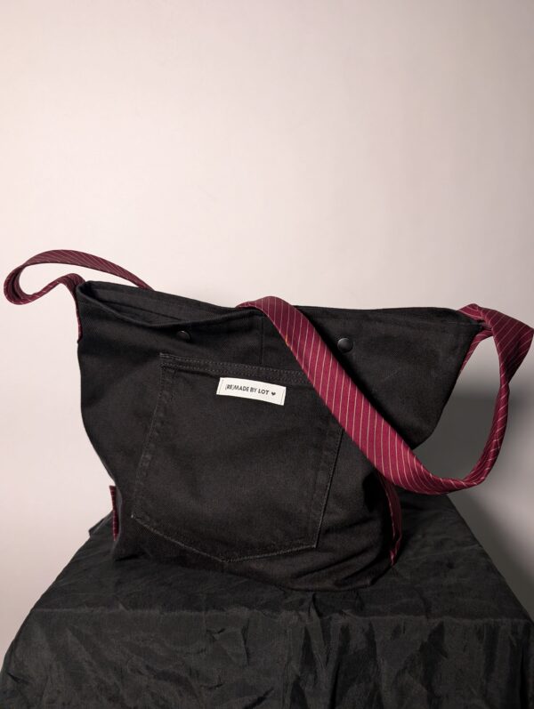 (RE)MADE BY LOT zwarte denim tas met schuine pocket en hengsels gemaakt van een hergebruikte bordeauxrode stropdas.