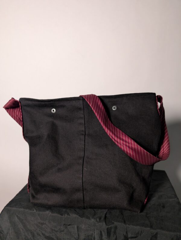 (RE)MADE BY LOT zwarte denim tas met schuine pocket en hengsels gemaakt van een hergebruikte bordeauxrode stropdas.