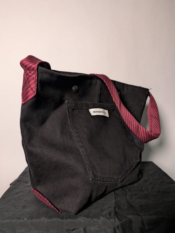 (RE)MADE BY LOT zwarte denim tas met schuine pocket en hengsels gemaakt van een hergebruikte bordeauxrode stropdas.
