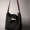 (RE)MADE BY LOT zwarte denim tas met schuine pocket en hengsels gemaakt van een hergebruikte bordeauxrode stropdas.