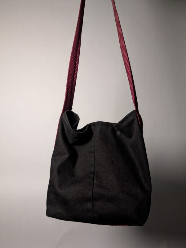 (RE)MADE BY LOT zwarte denim tas met schuine pocket en hengsels gemaakt van een hergebruikte bordeauxrode stropdas.