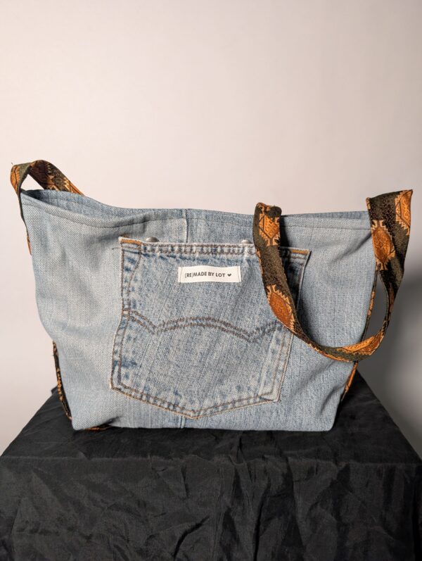 Denim tie-up 01 (RE)MADE BY LOT denim tas van lichtblauwe vintage jeans met back pocket en hengsels gemaakt van een hergebruikte stropdas.