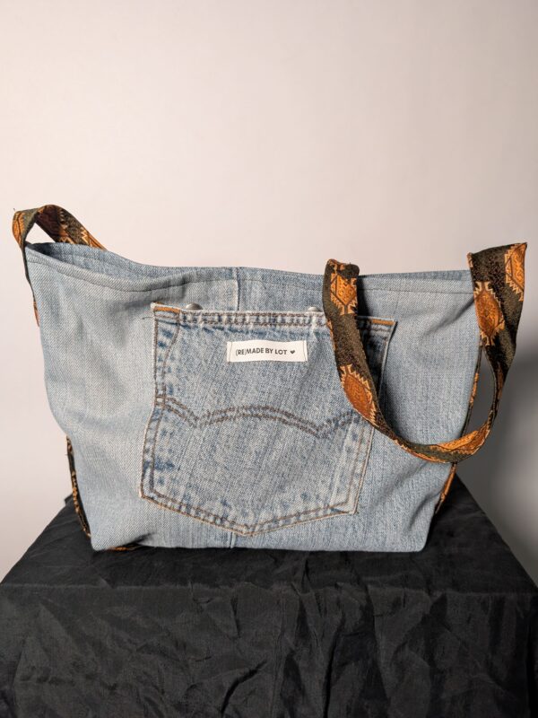 (RE)MADE BY LOT denim tas van lichtblauwe vintage jeans met back pocket en hengsels gemaakt van een hergebruikte stropdas.