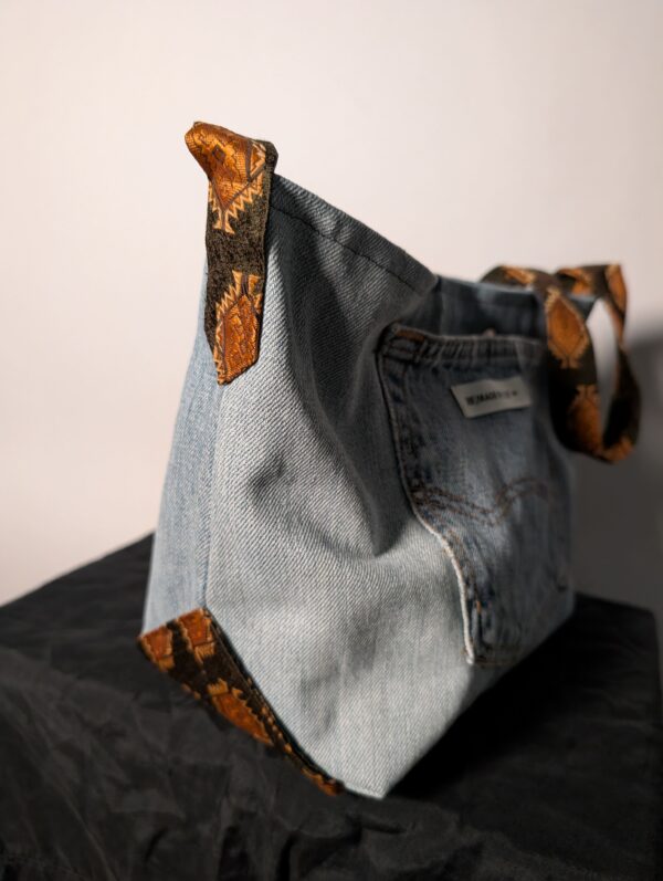 Denim tie-up 06 (RE)MADE BY LOT denim tas van lichtblauwe vintage jeans met back pocket en hengsels gemaakt van een hergebruikte stropdas.