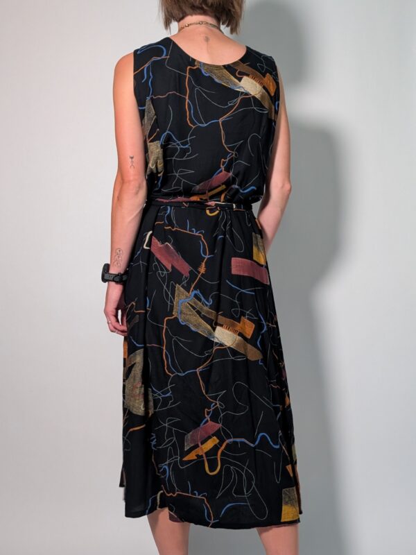 Vintage donkerblauwe mouwloze maxi jurk met abstracte print in blauw, oker en roest, knoopsluiting en strikceintuur.
