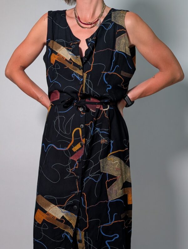 Abstract line 03 Vintage donkerblauwe mouwloze maxi jurk met abstracte print in blauw, oker en roest, knoopsluiting en strikceintuur.