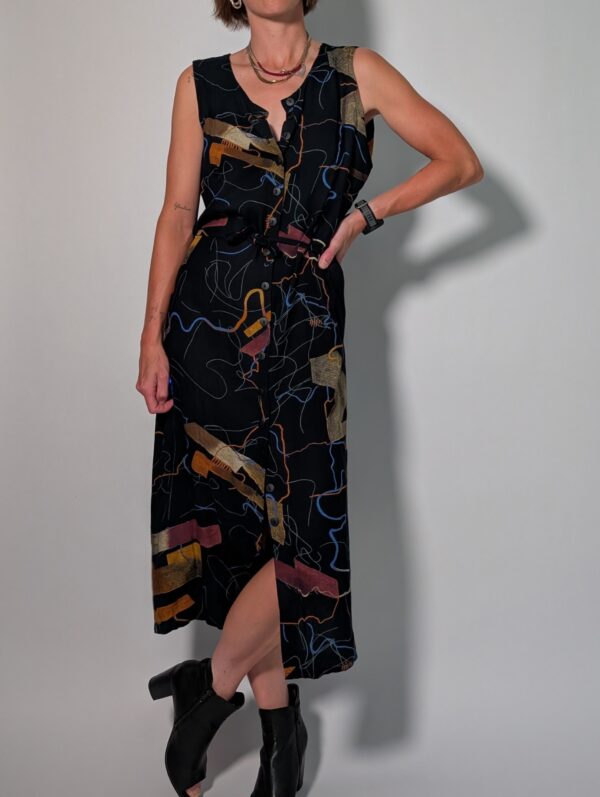 Abstract line 04 Vintage donkerblauwe mouwloze maxi jurk met abstracte print in blauw, oker en roest, knoopsluiting en strikceintuur.