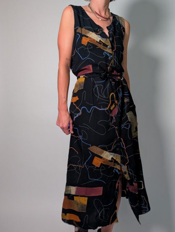 Abstract line 05 Vintage donkerblauwe mouwloze maxi jurk met abstracte print in blauw, oker en roest, knoopsluiting en strikceintuur.